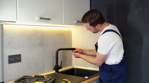 修理厨房靠近水槽的水龙头 厨房的管道工安装了一个新的水龙头 — 图库视频影像