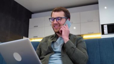Meşgul bir işçi yöneticisi, dizüstü bilgisayardaki bilgileri telefonla kontrol ederek müşteriye danışıyor. Profesyonel tele-işçi broker satıcısı, telefon laptopunu kullanarak mal hizmetleri sunuyor..