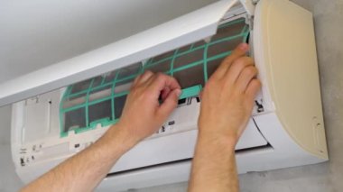 Usta ev klimasını temizliyor.