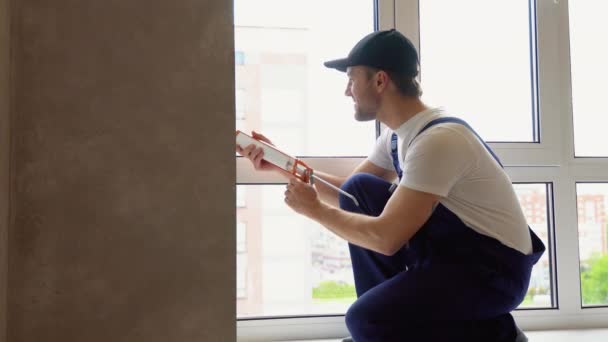 Arbeiter Overalls Mit Silikonschlauch Zur Reparatur Von Fenstern Innenbereich — Stockvideo