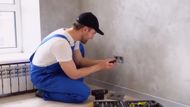 Elektricien Uniform Monteren Van Stopcontacten Grijze Wand Binnen — Stockvideo