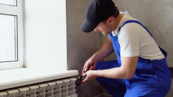用扳手修理散热器的工人 清除散热器中的空气 并解决加热问题 公寓内暖气散热器的拆卸和修理 — 图库视频影像