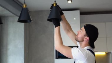 Elektrikçi tavan arasına lamba ışıklandırması ve spot çatı katı tarzı kuruyor.