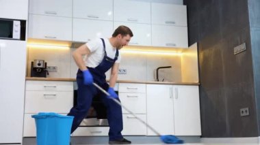 Komik, neşeli profesyonel temizlikçi paspas tasvirleriyle mola sırasında bilardo oynuyor.