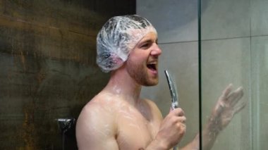 Duşta şarkı söyleyen sakallı genç adam onu gözetleyen birinin korkmuş ve şaşırmış göründüğünü keşfediyor. Komedi sahnesi.