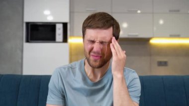Stresli hissediyorum. Sinirli yakışıklı genç adam başını dokunmadan ve evde kanepede otururken gözleri kapalı tutmak