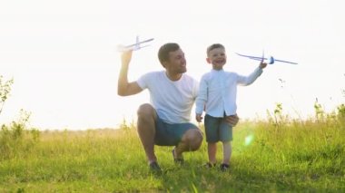 Baba ve çocuk takım çalışması, aile hayalleri ve fantezileri. Mutlu aile babası, bebek ve oğul oyuncak uçakla birlikte oynuyorlar..