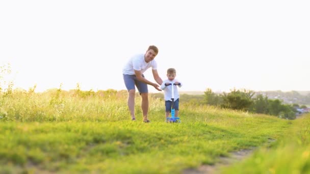Assistência Familiar Sorrindo Pai Adulto Ensinando Seu Filho Pedalar Campo — Vídeo de Stock