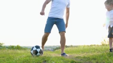 Mutlu adam oğluyla futbol oynuyor..