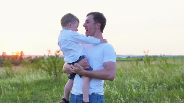 夏天日落时 快乐的男人抱着儿子在户外玩耍 — 图库视频影像