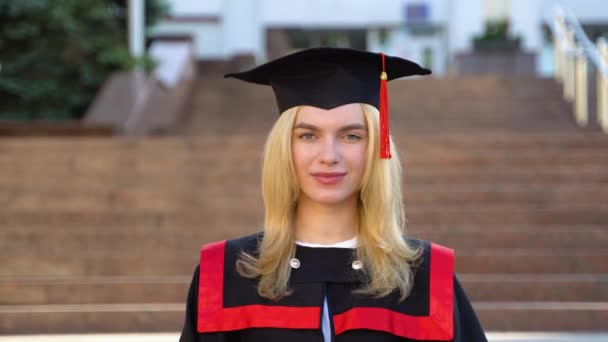 女毕业生穿着毕业典礼服装和毕业典礼帽 — 图库视频影像