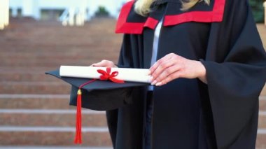 Mezuniyet gününde diploma ya da eğitim diploması tutan kız öğrencinin eli, başarılı eğitim kavramı