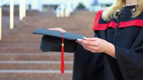 卒業生の若い女性は黒のガウンを着用し 手で証明書を保持し 閉じます 教育理念 — ストック動画