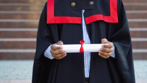 卒業生のインド人男性は黒のガウンを着用し 手で証明書を保持し 閉じます 教育理念 — ストック動画