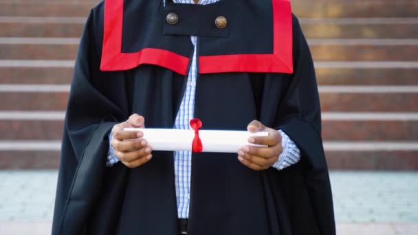 卒業生のインド人男性は黒のガウンを着用し 手で証明書を保持し 閉じます 教育理念 — ストック動画