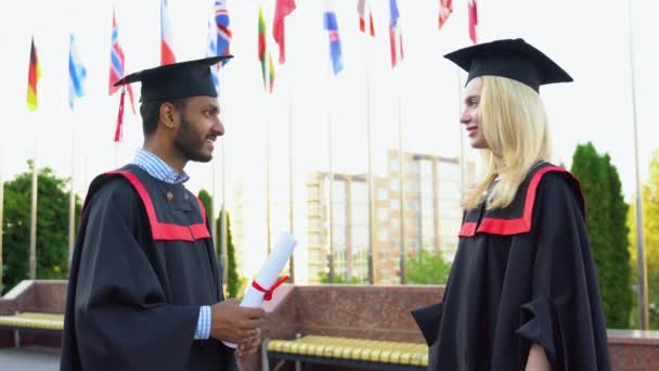 Zwei Multiethnische Absolventen Des Masterstudiengangs Machen Eine Geste Mit Diplomen — Stockvideo