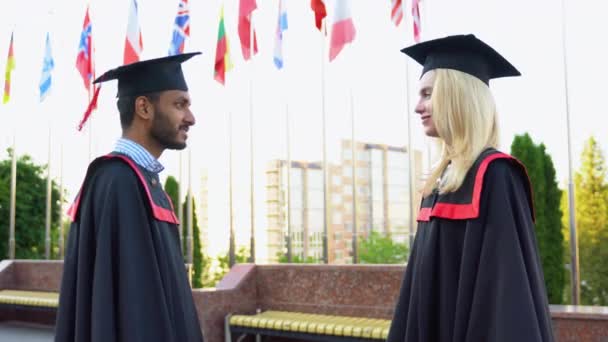 Zwei Indische Und Kaukasische Absolventen Gratulieren Einander Zum Abschluss — Stockvideo