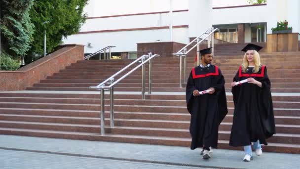 Due Laureati Multirazziali Che Camminano Nel Campus Universitario — Video Stock