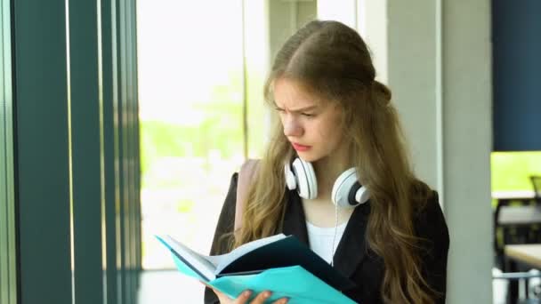 Ένα Μπερδεμένο Κορίτσι Διαβάζει Ένα Βιβλίο Πριν Τις Εξετάσεις Μαθήτρια — Αρχείο Βίντεο
