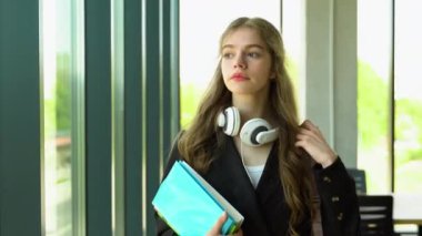 Kameraya doğru yürüyen sevimli bayan üniversite öğrencisi.