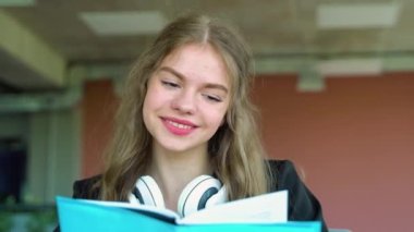 Lise üniversitesinde kitap okuyan neşeli kız sınava hazırlanıyor..