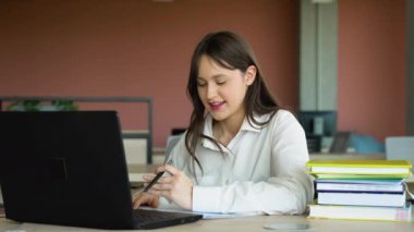 Sınıfta dizüstü bilgisayar kullanan odaklanmış kız, çekici kız öğrenci öğrenme dili, çevrimiçi webinar izleme, ses kursu dinleme, e-öğrenme konsepti