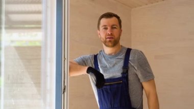 Tahta prefabrik evde tornavidayla pencere kurucusunun portresi.
