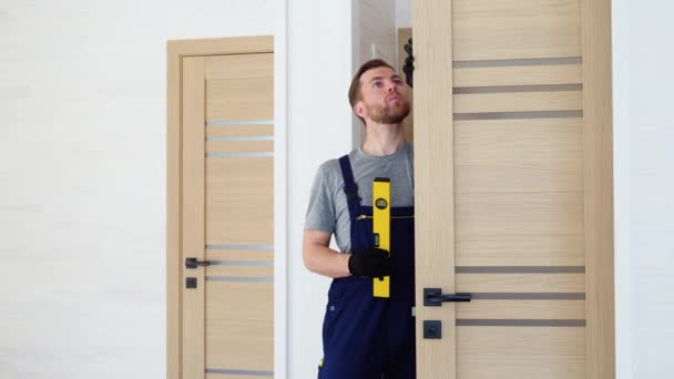 Tukang Kayu Laki Laki Memasang Pintu Kayu Interior Dengan Tingkat — Stok Video