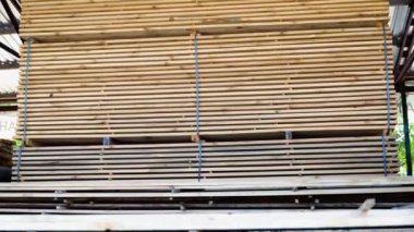 Yığınla kereste. Katlanmış odun. Kapalı ahşap tahtalar. Tahtanın sonundaki yüzey. Depoda üst üste yığılmış bir sürü tahta var. İnşaatta kullanılacak odun.