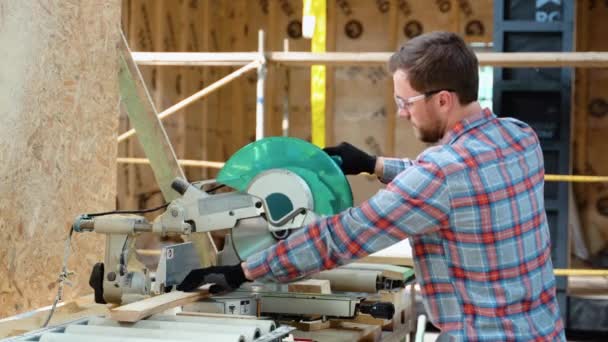 建筑工人用手持式蜗杆传动圆锯在新的住宅建设项目中切割木板 — 图库视频影像