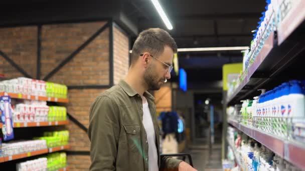 Ένας Άνδρας Αγοραστής Επιλέγει Σαμπουάν Αφρόλουτρο Στο Σούπερ Μάρκετ — Αρχείο Βίντεο