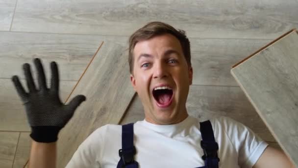 Смішний Працівник Тесля Лежить Підлозі Тримаючи Паркетну Дошку — стокове відео