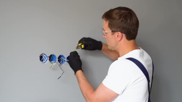 在新房子里安装壁套的专业电工技师 家里的电器修理 电工为电源插座安装电线 — 图库视频影像