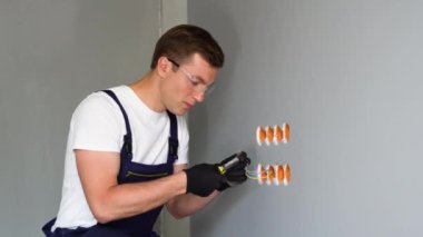 Profesyonel elektrik teknisyeni yeni yeni bir eve duvar soketi takıyor. Elektrik prizleri için kablo montajı.