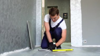 Seramik fayanslar yerleştiriliyor. Parçaları ölçüyor ve kesiyor..