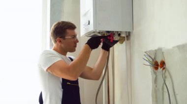 Professional engineer installing a natural gas boiler at home, he is checking the pipes.