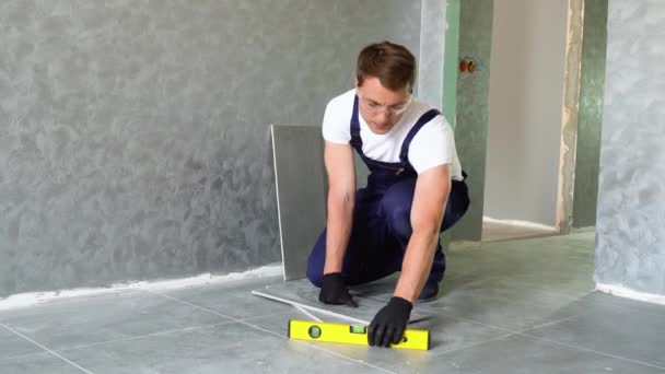 Trabalhador Sentado Chão Instalar Nível Carpinteiro Azulejos Recém Colocados Apartamento — Vídeo de Stock