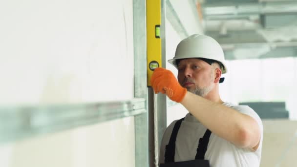 Ein Bauarbeiter Misst Die Vertikale Abweichung Der Gipskartonwand Blasenpegel Lineal — Stockvideo