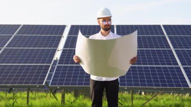 Bir mühendis güneş istasyonunun tasarım belgelerini kontrol eder..