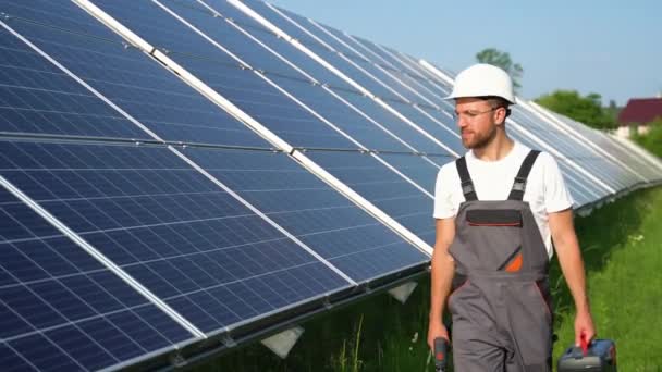 Zonne Energiecentrale Met Ingenieur Beschermende Werkkleding Lopen Onderzoeken Fotovoltaïsche Panelen — Stockvideo