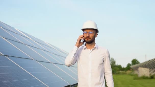 自信的工程师戴着安全帽 拿着手机 打电话 从事太阳能电池板概念工作的工程师 工人或建筑师 — 图库视频影像