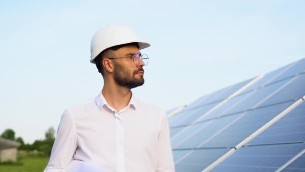 太阳能发电厂与工程师在保护工作服步行和检查光电面板 替代能源的概念及其维护 — 图库视频影像