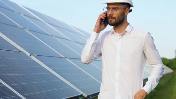 自信的工程师戴着安全帽 手持手机 打电话 从事太阳能电池板概念工作的工程师 工人或建筑师 — 图库视频影像