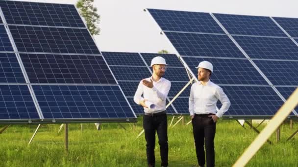 由两名工程师组成的太阳能农场步行去检查系统的运行情况 使用替代能源来保护世界能源 用于清洁能源生产的光电模块构想 — 图库视频影像