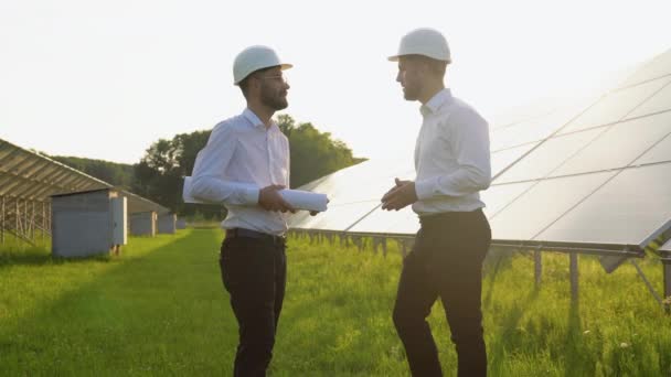 Dos Ingenieros Discutiendo Contentos Éxito Durante Trabajo Granja Solar Panel — Vídeo de stock