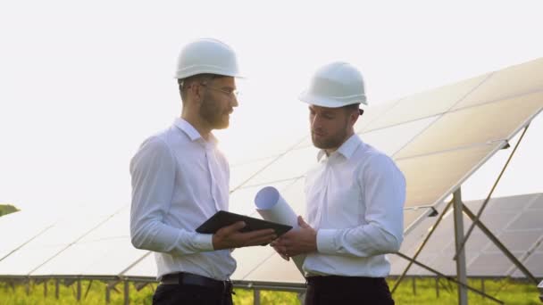 Dos Hombres Con Cascos Duros Discutiendo Proyecto Granja Solar Ingenieros — Vídeos de Stock