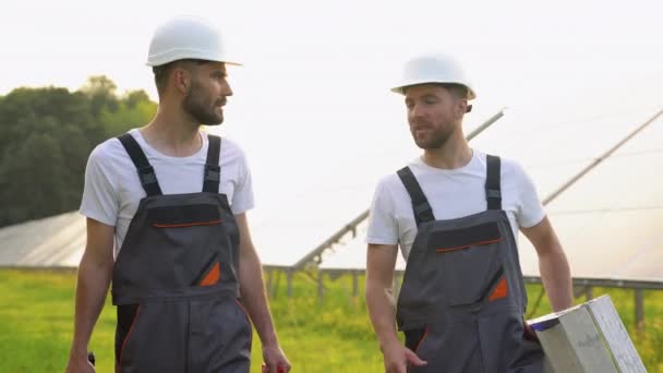 Solarkraftwerk Mit Zwei Ingenieuren Schutzkleidung Die Mit Werkzeug Gehen Und — Stockvideo