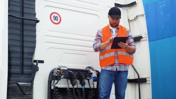 Profesjonalny Uśmiechnięty Kierowca Ciężarówki Sprawdzanie Pomocą Komputera Typu Tablet Stoi — Wideo stockowe
