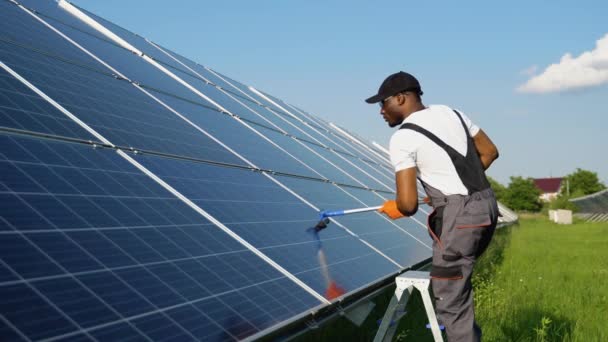 Schwarzer Photovoltaik Techniker Reinigt Und Wäscht Die Oberfläche Der Solarzellen — Stockvideo