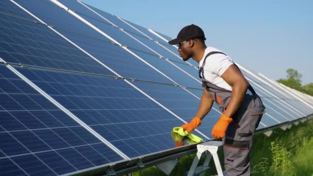 Técnico Fotovoltaico Negro Limpiando Lavando Superficie Los Paneles Solares — Vídeos de Stock